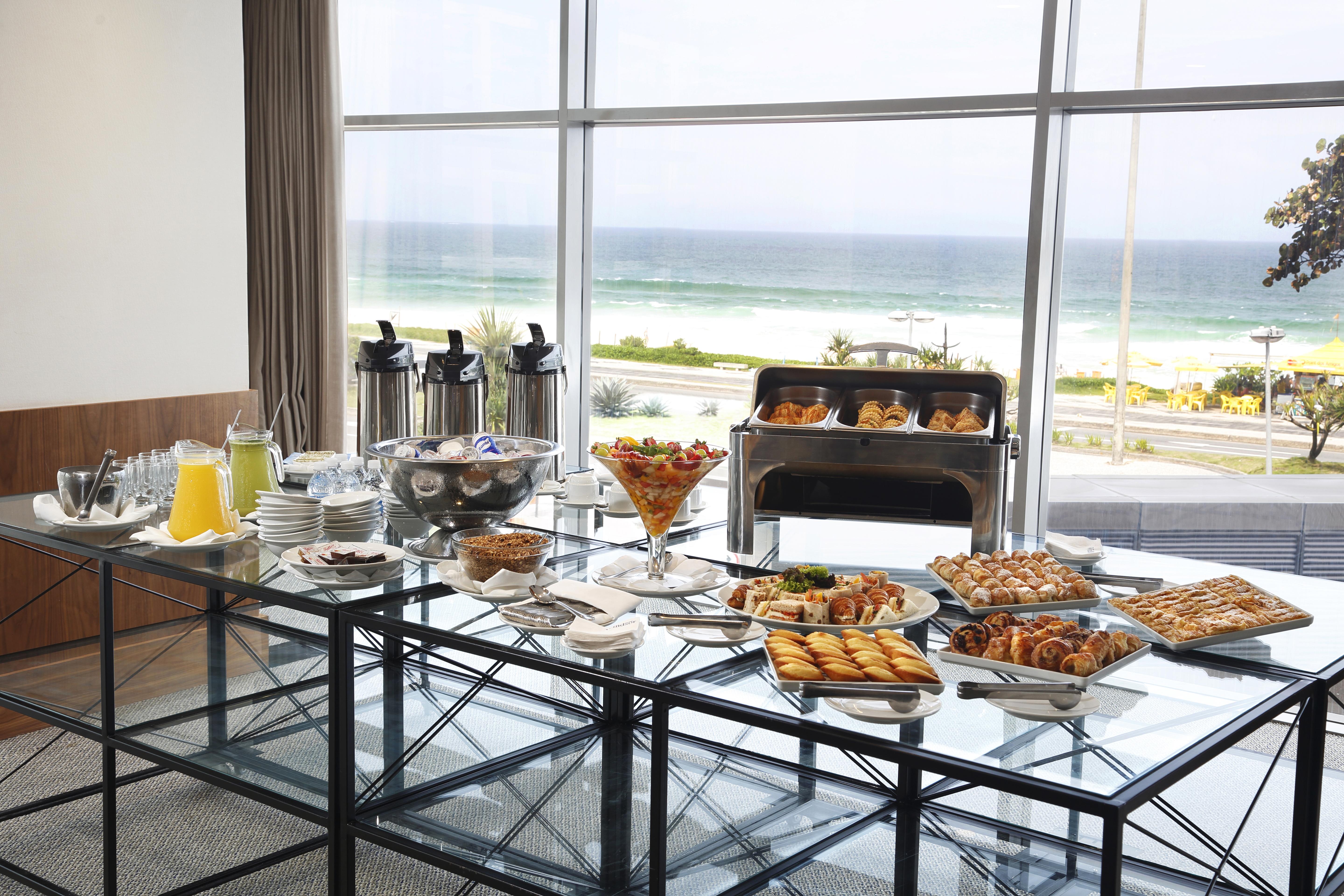 Windsor Marapendi Hotel Рио де Жанейро Екстериор снимка The photo shows a beautifully arranged buffet table with a variety of food items. In the foreground, there are multiple plates and bowls filled with different dishes, including pastries, fruits, and savory items. There are also drinks available, such